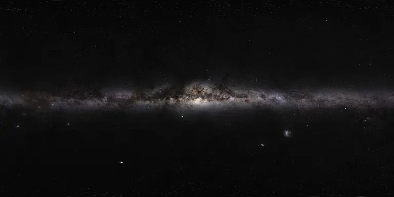 The Milky Way’s bright central bulge and dust-darkened stellar band span a panoramic sky filled with stars, seen from Earth.